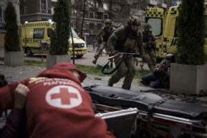 Ukrainian servicemen run for cover as explosions are heard during a Russian attack in downtown Kharkiv, Ukraine, Sunday, April 17, 2022. (AP Photo/Felipe Dana)