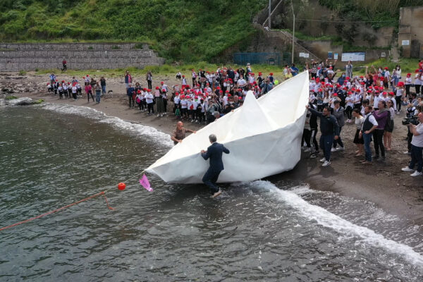 Da Procida alla terraferma su una barca di carta, l’origami affonda a metà strada: ”Fragile come quelle dei migranti”
