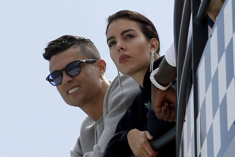 FILE – Cristiano Ronaldo, left, is flanked by his partner Georgina Rodriguez as they watch the second practice session at the Monaco racetrack, in Monaco, Thursday, May 23, 2019. (AP Photo/Luca Bruno, File)