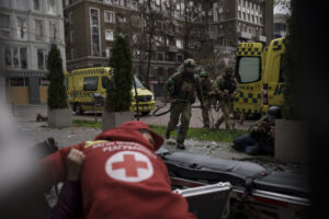 Ukrainian servicemen run for cover as explosions are heard during a Russian attack in downtown Kharkiv, Ukraine, Sunday, April 17, 2022. (AP Photo/Felipe Dana)
