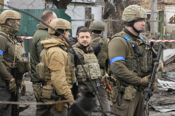 Ukrainian President Volodymyr Zelenskyy examines the site of a recent battle, in Bucha close to Kyiv, Ukraine, Monday, Apr. 4, 2022. Russia is facing a fresh wave of condemnation after evidence emerged of what appeared to be deliberate killings of civilians in Ukraine. (AP Photo/Efrem Lukatsky)