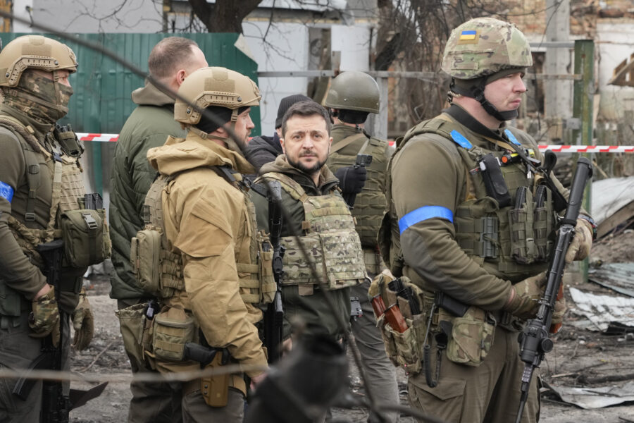 Ukrainian President Volodymyr Zelenskyy examines the site of a recent battle, in Bucha close to Kyiv, Ukraine, Monday, Apr. 4, 2022. Russia is facing a fresh wave of condemnation after evidence emerged of what appeared to be deliberate killings of civilians in Ukraine. (AP Photo/Efrem Lukatsky)