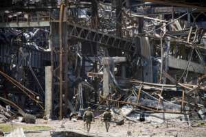 Russian soldiers walk through debris of the Metallurgical Combine Azovstal, in Mariupol, on the territory which is under the Government of the Donetsk People’s Republic control, eastern Ukraine, Monday, June 13, 2022. The plant was almost completely destroyed during the siege of Mariupol. This photo was taken during a trip organized by the Russian Ministry of Defense. (AP Photo)