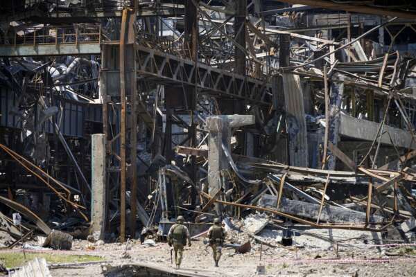 Russian soldiers walk through debris of the Metallurgical Combine Azovstal, in Mariupol, on the territory which is under the Government of the Donetsk People’s Republic control, eastern Ukraine, Monday, June 13, 2022. The plant was almost completely destroyed during the siege of Mariupol. This photo was taken during a trip organized by the Russian Ministry of Defense. (AP Photo)