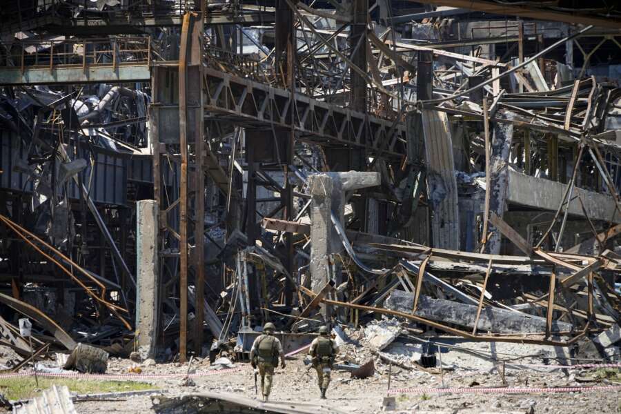 Russian soldiers walk through debris of the Metallurgical Combine Azovstal, in Mariupol, on the territory which is under the Government of the Donetsk People’s Republic control, eastern Ukraine, Monday, June 13, 2022. The plant was almost completely destroyed during the siege of Mariupol. This photo was taken during a trip organized by the Russian Ministry of Defense. (AP Photo)