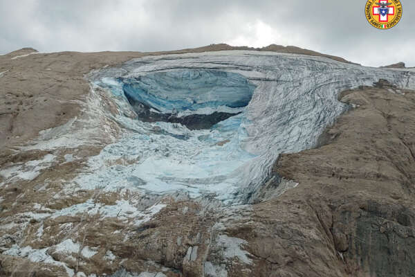 This image released on Sunday, July 3, 2022, by the Italian National Alpine and Cave Rescue Corps shows the glacier in Italy’s Alps near Trento a large chunk of which has broken loose, killing at least six hikers and injuring eight others. Alpine rescue service officials, which provided that toll Sunday evening, said it could take hours to determine if any hikers might be missing. The National Alpine and Cave Rescue Corps tweeted that the search of the involved area of Marmolada peak involved at least five helicopters and rescue dogs. (Corpo Nazionale Soccorso Alpino e Speleologico via AP)