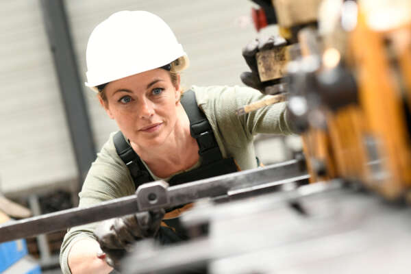 Woman with helmet working in metallurgy factory