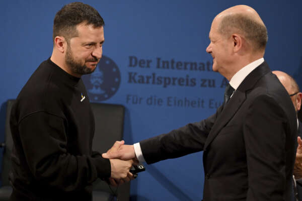 Ukrainian President Volodymyr Zelenskyy, left, and German Chancellor Olaf Scholz, right, shake hands during the award ceremony of the Charlemagne Prize in Aachen, Germany, Sunday, May 14, 2023. Zelenskyy is in Aachen to receive the International Charlemagne Prize, awarded to him and the people of Ukraine. (Ina Fassbender/Pool Photo via AP)