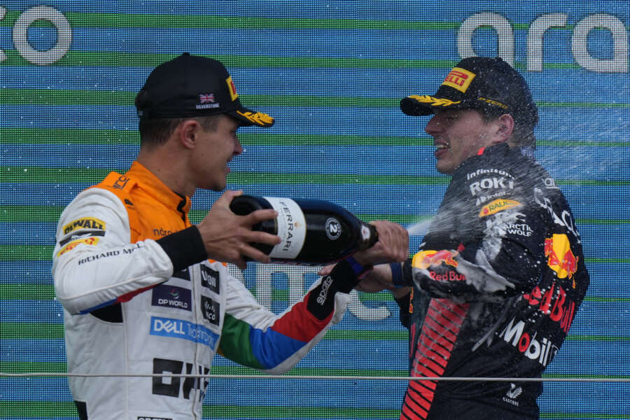 McLaren driver Lando Norris of Britain, left, sprays champagne on Red Bull driver Max Verstappen of the Netherlands celebrates his second place after the British Formula One Grand Prix race at the Silverstone racetrack, Silverstone, England, Sunday, July 9, 2023. (AP Photo/Luca Bruno)