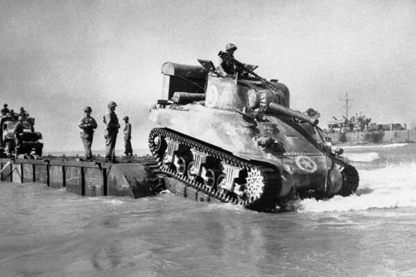 An American tank rolls off a landing craft to move ashore on Sicily, Italy on July 26, 1943. (AP Photo)