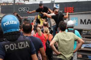 Napoli, manifestanti violenti contro lo stop al Reddito di cittadinanza bloccano l’autostrada invocando: “Conte, Conte, Conte!”. Una donna mangia i croccantini per i gatti
