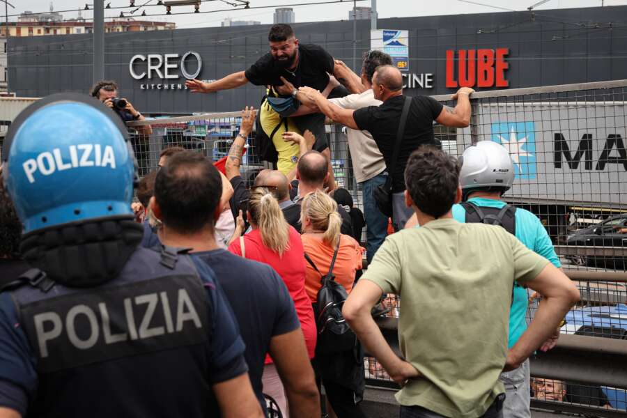 Napoli, manifestanti violenti contro lo stop al Reddito di cittadinanza bloccano l’autostrada invocando: “Conte, Conte, Conte!”. Una donna mangia i croccantini per i gatti
