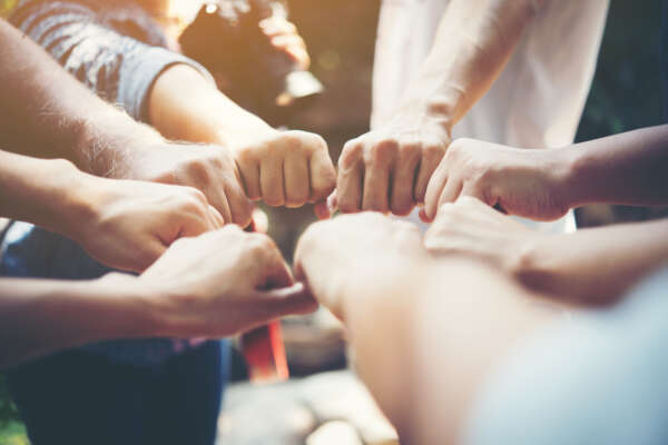 Close up of young people putting their hands together. Team with stack of hands showing unity and teamwork.