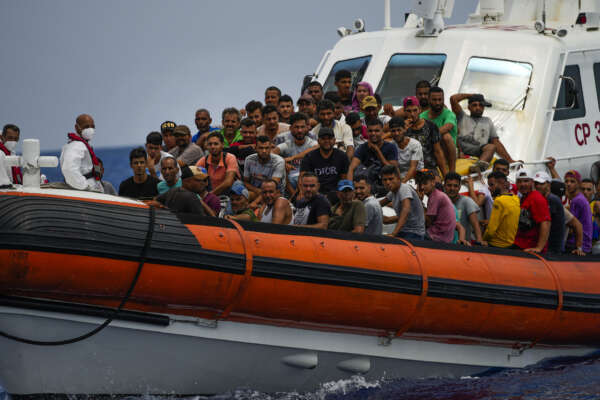 Migrants mostly from Tunisia rest on board an Italian coast guard ship after being rescued southwest of the Italian island of Lampedusa in the Mediterranean sea, Saturday, Aug. 6, 2022. (AP Photo/Francisco Seco)