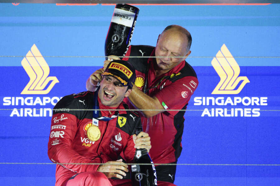 Ferrari driver Carlos Sainz of Spain reacts as a teammate pours champagne over him as he celebrates on the podium after winning the Singapore Formula One Grand Prix at the Marina Bay circuit, Singapore,Sunday, Sept. 17, 2023. (AP Photo/Vincent Thian)