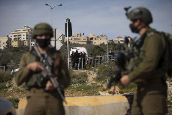 Israeli forces secure the area where the military said troops killed a Palestinian man suspected of trying to attack soldiers, at a West Bank junction near the joint Israeli-Palestinian industrial zone of Barkan, Tuesday, Jan. 26, 2021. (AP Photo/Majdi Mohammed)