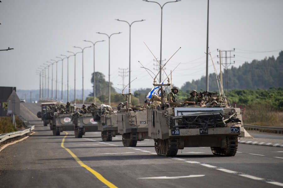 Israeli soldiers carry supplies near the border with Lebanon on Tuesday, Oct. 10, 2023. (AP Photo/Gil Eliyahu)