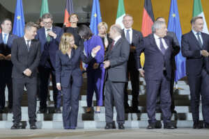 German Chancellor Olaf Scholz, center right, and Italian Prime Minister Giorgia Meloni, center left, advise their ministers for a family photo during a meeting of the German and Italian government at the chancellery in Berlin, Germany, Wednesday, Nov. 22, 2023. (AP Photo/Markus Schreiber)
