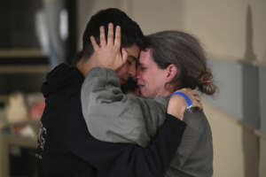 This handout photo provided by Haim Zach/GPO shows Sharon Hertzman, right, hugging a relative as they reunite at Sheba Medical Center in Ramat Gan, Israel, Saturday Nov. 25, 2023. Sharon Hertzman and her daughter Noam, 12 years old, not pictured, were released by Hamas after being held as hostages in Gaza for 50 days. (Haim Zach/GPO/Handout via AP)