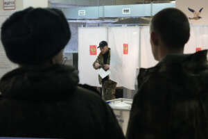A Russian serviceman leaves a voting booth at a polling station during a presidential election in St. Petersburg, Russia, Friday, March 15, 2024. Voters in Russia are heading to the polls for a presidential election that is all but certain to extend President Vladimir Putin’s rule after he clamped down on dissent. (AP Photo/Dmitri Lovetsky)