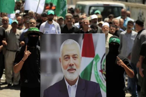 Hamas members hold a poster of Hamas political chief Ismail Haniyeh during a protest to condemn his killing, at al-Bass Palestinian refugee camp, in the southern port city of Tyre, Lebanon, Wednesday, July 31, 2024. Haniyeh, Hamas’ political chief in exile who landed on Israel’s hit list after the militant group staged its surprise Oct. 7 attacks, was killed in an airstrike in the Iranian capital early Wednesday. (AP Photo/Mohammed Zaatari)