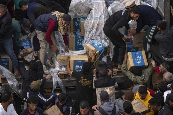 Palestinians loot a humanitarian aid truck as it crossed into the Gaza Strip in Rafah, Sunday, Dec. 17, 2023. (AP Photo/Fatima Shbair)