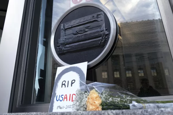 FILE – Flowers and a sign are placed outside the headquarters of the U.S. Agency for International Development, or USAID, Feb. 7, 2025, in Washington. (AP Photo/Jose Luis Magana, File)