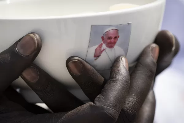 A priest holds a sacrament bowl showing a photograph of Pope Francis at a Holy Mass at the John Garang Mausoleum in Juba, South Sudan Sunday, Feb. 5, 2023. (AP Photo/Ben Curtis, File)