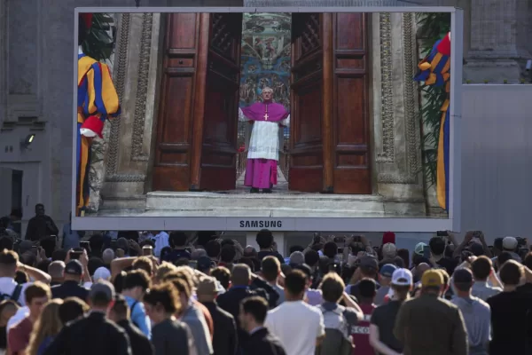 A giant screen in St Peter’s Basilica shows a Vatican official closing the door to the Sistine Chapel after calling out “extra omnes”, Latin for “all out”, during the cardinals’ conclave to elect a new pope, at the Vatican, Wednesday, May 7, 2025. (AP Photo/Bernat Armangue)

Associated Press/LaPresse
