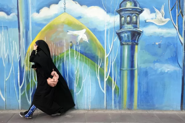 A head-to-toe veiled woman walks past a mural of a mosque, in downtown Tehran, Iran, Thursday, Feb. 22, 2024. Candidates for Iran’s March 1, parliamentary election began campaigning Thursday in the country’s first election since the bloody crackdown on the 2022 nationwide protests that followed the death of 22-year-old Mahsa Amini in police custody. (AP Photo/Vahid Salemi)