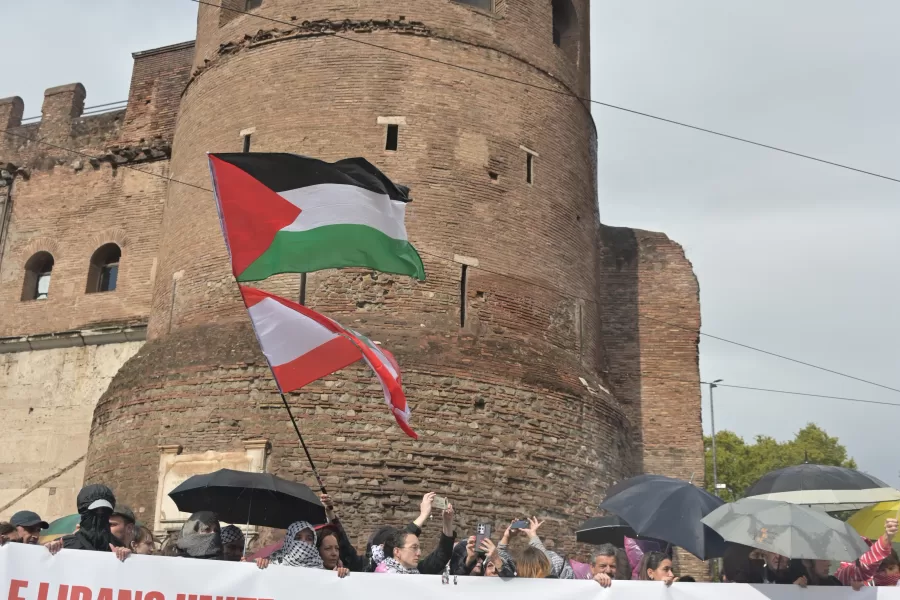 MANIFESTANTI MANIFESTAZIONE PRO PALESTINA BANDIERA PALESTINA STRISCIONE FERMIAMO IL GENOCIDIO