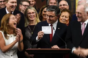 Speaker of the House Mike Johnson, R-La., surrounded by Republican members of Congress, holds up the final vote count while speaking following the passage of President Donald Trump’s signature bill of tax breaks and spending cuts, Thursday, July 3, 2025, at the Capitol in Washington. (AP Photo/Julia Demaree Nikhinson)