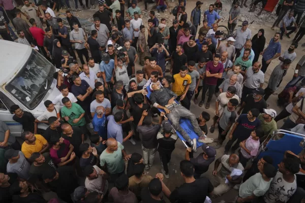 Mourners carry the body of a Palestinian man who was killed while trying to reach aid trucks entering northern Gaza through the Zikim crossing with Israel, at Shifa Hospital in Gaza City, Thursday, July 31, 2025. (AP Photo/Jehad Alshrafi)