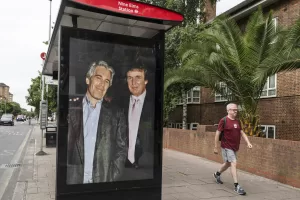Associated Press/LaPresse
Commuters walk past a bus stop near Nine Elms Station as activists put up a poster showing President Donald Trump and Jeffrey Epstein near the US Embassy in London, Thursday, July 17, 2025.(AP Photo/Thomas Krych)
