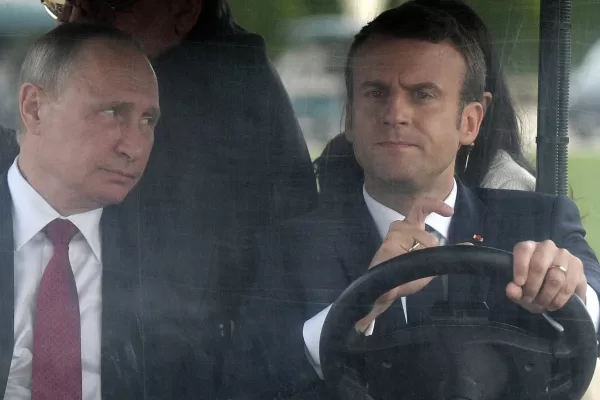 FILE – French President Emmanuel Macron, right, drives an electric golf car with Russian President Vladimir Putin in the garden of the Versailles Palace following their meeting in Versailles, near Paris, France, Monday, May 29, 2017. (Alexei Nikolsky/Sputnik, Kremlin Pool Photo via AP, File)