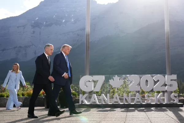 President Donald Trump walks with Canada’s Prime Minister Mark Carney after a group photo at the G7 Summit, Monday, June 16, 2025, in Kananaskis, Canada, as Italy’s Prime Minister Giorgia Meloni follows. (AP Photo/Mark Schiefelbein)
