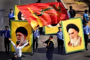 A Lebanese Shiite supporter of Iranian-backed Hezbollah group, waves a flag with the name of Imam Hussein as Hezbollah scouts carry portraits of of the late revolutionary founder Ayatollah Khomeini, right, and for the Supreme Leader Ayatollah Ali Khamenei, left, during the holy day of Ashoura that commemorates the 7th century martyrdom of the Prophet Muhammad’s grandson Hussein, in the southern suburb of Beirut, Lebanon, Tuesday, Aug. 9, 2022. The leader of Lebanon’s Hezbollah group Sheikh Hassan Nasrallah warned archenemy Israel on Tuesday over the two countries’ maritime border dispute. (AP Photo/Hussein Malla) A Lebanese Shiite supporter of Iranian-backed Hezbollah group, waves a flag with the name of Imam Hussein as Hezbollah scouts carry portraits of of the late revolutionary founder Ayatollah Khomeini, right, and for the Supreme Leader Ayatollah Ali Khamenei, left, during the holy day of Ashoura that commemorates the 7th century martyrdom of the Prophet Muhammad’s grandson Hussein, in the southern suburb of Beirut, Lebanon, Tuesday, Aug. 9, 2022. The leader of Lebanon’s Hezbollah group Sheikh Hassan Nasrallah warned archenemy Israel on Tuesday over the two countries’ maritime border dispute. (AP Photo/Hussein Malla)
