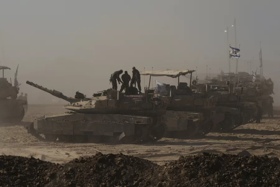 Israeli soldiers stand on the top of a tank parked on an area near the Israeli-Gaza border, as seen from southern Israel, Monday, Aug. 18, 2025. (AP Photo/Maya Levin)
