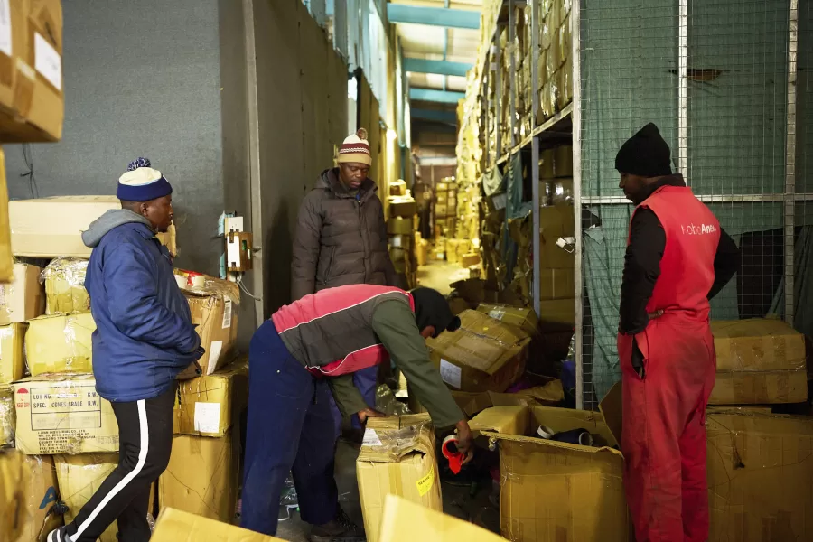 Workers wrap boxes with the last leftover garments inside the empty Tzicc clothing factory following the threat of U.S.-imposed tariffs in Maseru, Lesotho, Tuesday, July 22, 2025. (AP Photo/Bram Janssen)