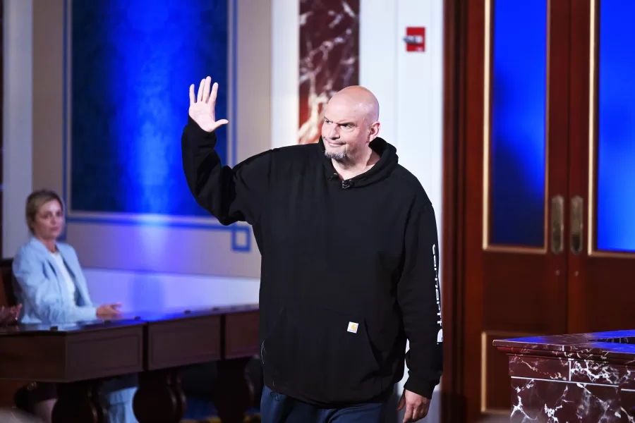 Sen. John Fetterman, D-Pa., center, waves as he arrives for a debate with Sen. Dave McCormick, R-Pa., not shown, Monday, June 2, 2025, at the Edward M. Kennedy Institute for the United States Senate, Monday, June 2, 2025, in Boston, as livestreamed on Fox Nation. (AP Photo/Steven Senne)