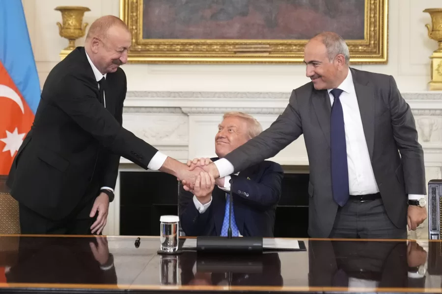 President Donald Trump, center, shakes hands with Armenian Prime Minister Nikol Pashinyan, right, and Azerbaijan President Ilham Aliyev during a trilateral signing ceremony in the State Dining Room of the White House, Friday, Aug. 8, 2025, in Washington. (AP Photo/Mark Schiefelbein)