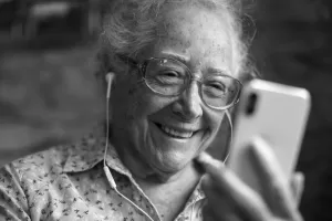 Happy elderly woman playing on the phone