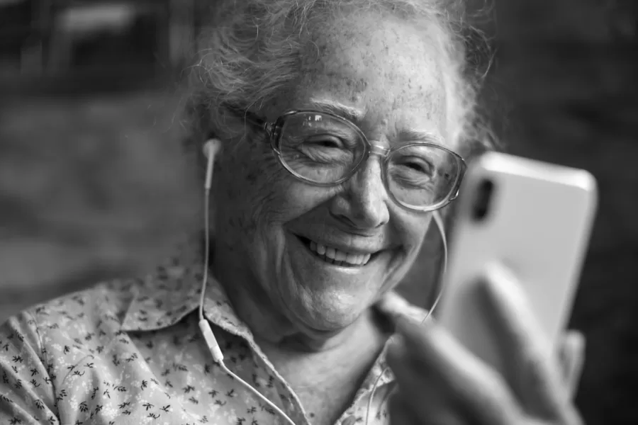 Happy elderly woman playing on the phone