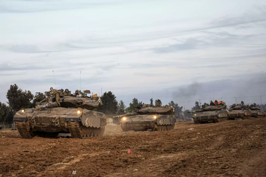Israeli soldiers move tanks at a staging area near the border with the Gaza Strip, southern Israel, Tuesday, Nov. 28, 2023. on the fifth day of a temporary cease-fire between Israel and Hamas. (AP Photo/Ohad Zwigenberg)