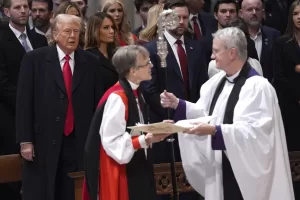 President Donald Trump, from left, watches as Rev. Mariann Budde arrives at the national prayer service at the Washington National Cathedral, Tuesday, Jan. 21, 2025, in Washington. (AP Photo/Evan Vucci) President Donald Trump, from left, watches as Rev. Mariann Budde arrives at the national prayer service at the Washington National Cathedral, Tuesday, Jan. 21, 2025, in Washington. (AP Photo/Evan Vucci)