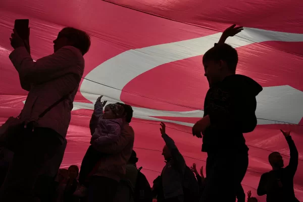 People walk under the giant Victory Banner unfolded at the WWII open-air museum at the Red Square in Moscow, Russia, Saturday, June 21, 2025, ahead of the 80th anniversary of the 1945 Victory Parade. (AP Photo/Pavel Bednyakov)