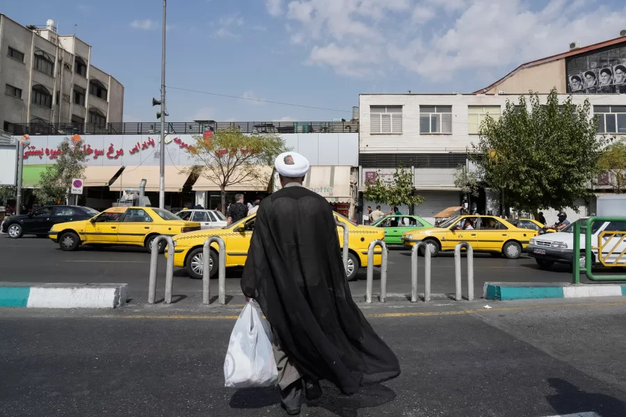 A cleric crosses the Enqelab-e-Eslami (Islamic Revolution) street, in Tehran, Iran, Saturday, Sept. 27, 2025. (AP Photo/Vahid Salemi)