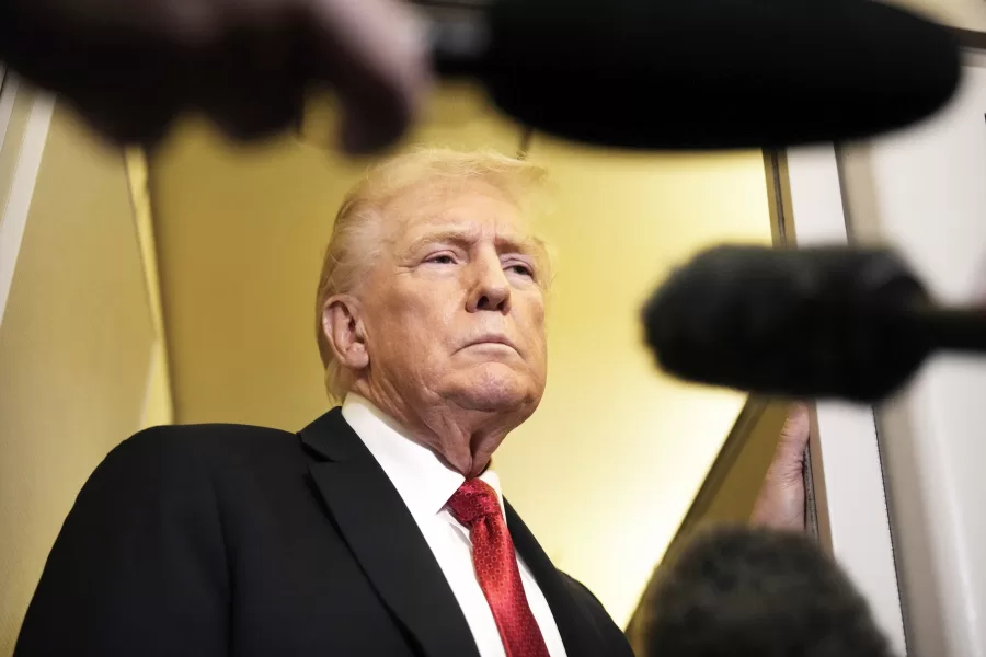 President Donald Trump speaks to reporters aboard Air Force One, Sunday, Oct. 19, 2025, en route to Joint Base Andrews, Md., as he returns from a trip to Florida. (AP Photo/Mark Schiefelbein)