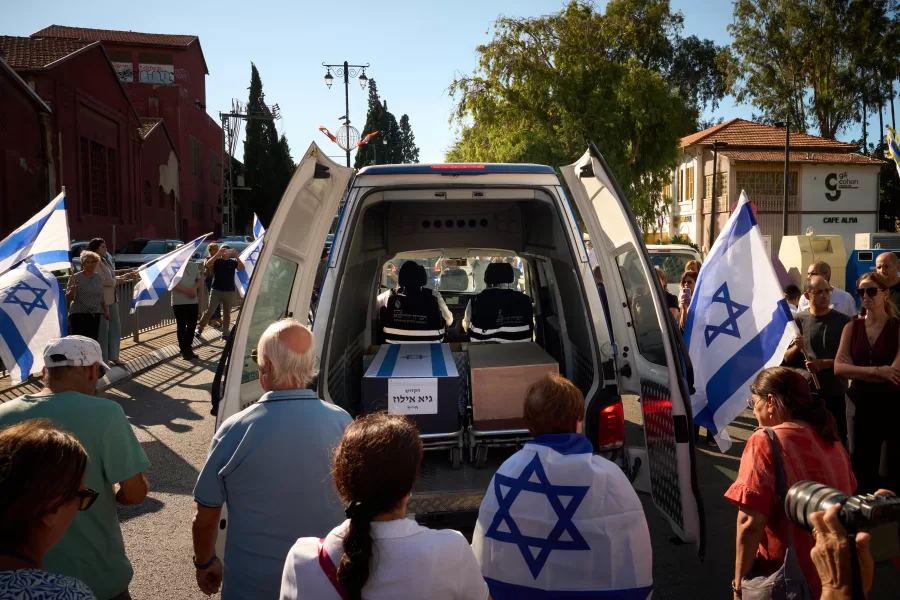 Mourners walk near the car carrying the coffin of slain hostage Guy Illouz during his funeral procession in Rishon Lezion, Israel, Wednesday, Oct. 15, 2025. Illouz remains were returned from Gaza to Israel as part of a ceasefire agreement between Israel and Hamas. (AP Photo/Emilio Morenatti)
