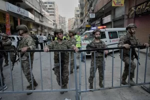 Army soldiers block a road that links to the site where an Israeli strike hit at an apartment building on Dahiyeh in the southern suburb of Beirut, Sunday Nov. 23, 2025. (AP Photo/Bilal Hussein)